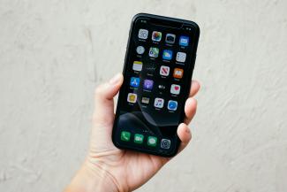 person holding black iphone 5 by Fujiphilm courtesy of Unsplash.