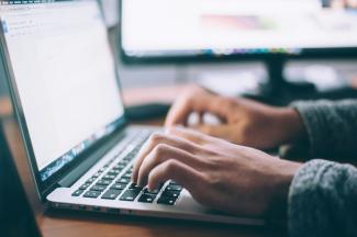 person using MacBook Pro by Glenn Carstens-Peters courtesy of Unsplash.